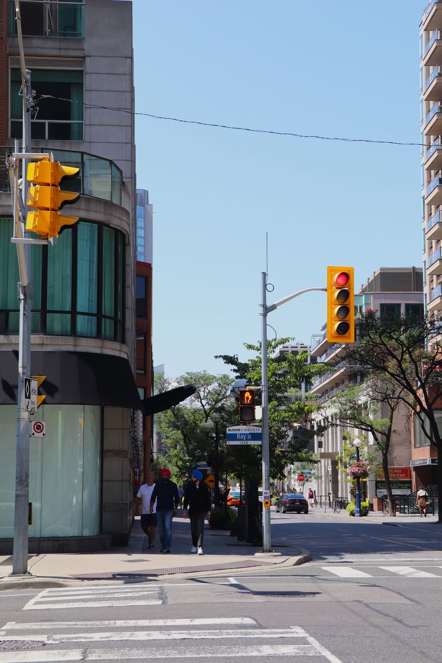 People walking along a Toronto street lined with local buildings